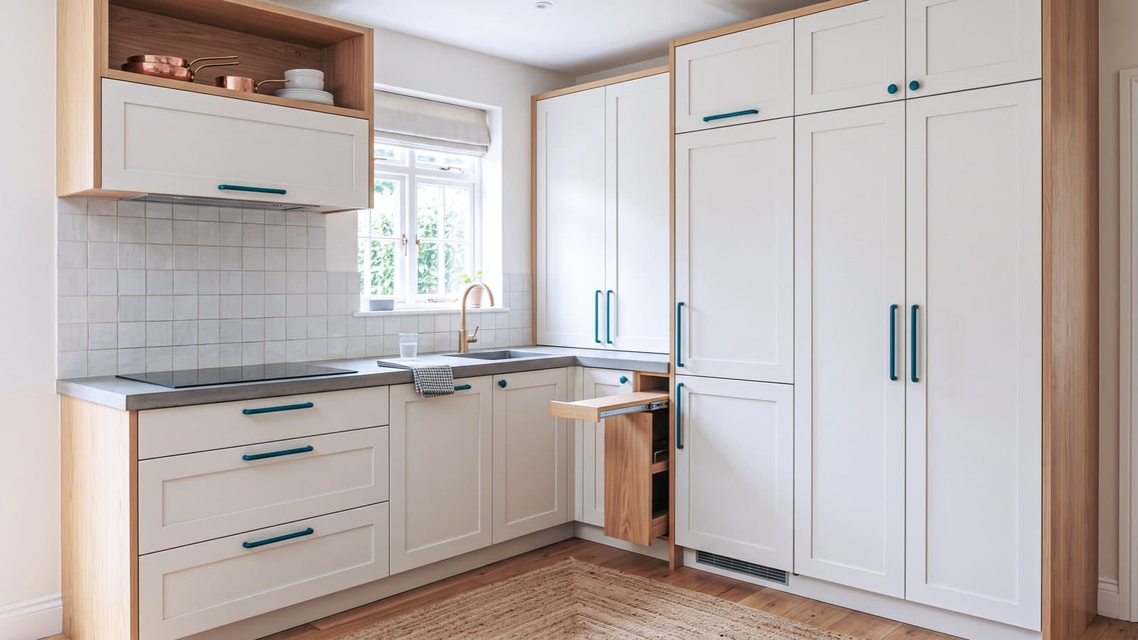Petite cuisine en I aux meubles blancs et bois clair, avec électroménager compact encastré